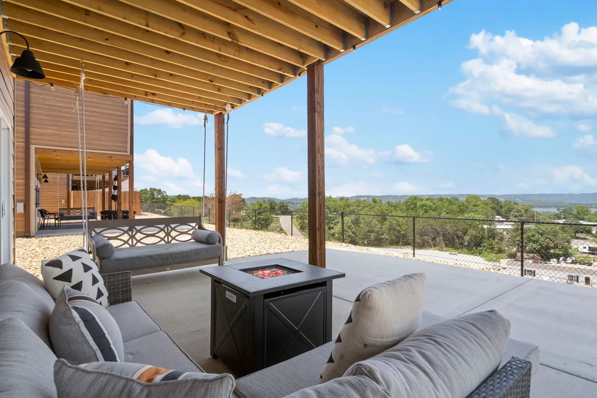 This inviting exterior scene centers on a communal fire pit surrounded by cozy outdoor seating, set against the backdrop of a scenic landscape. The area is designed for relaxing, sharing stories, and enjoying evenings together under the stars.